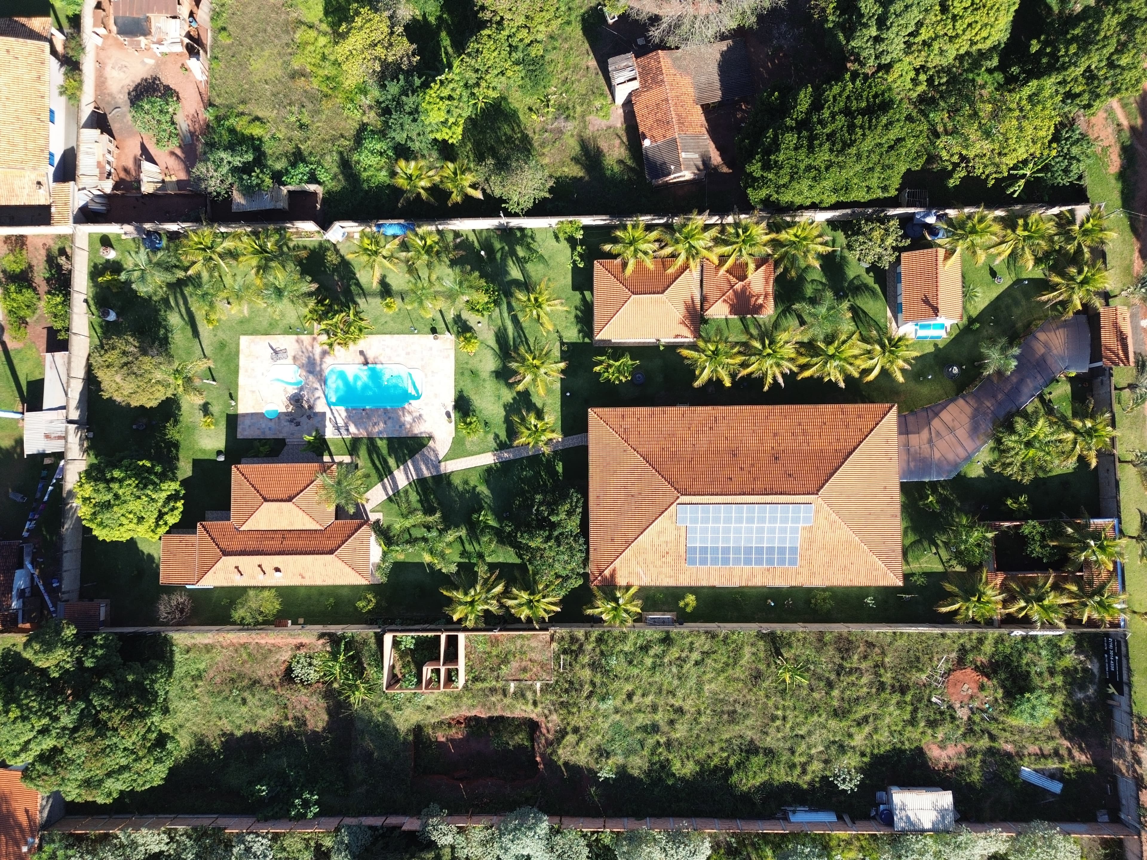 Vista aérea de chácara para eventos com piscina, jardim e coqueiros